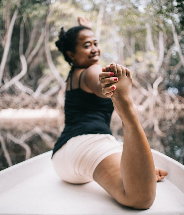 Woman in a peaceful yoga pose in a dark, serene environment.